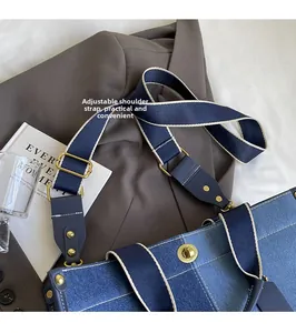 Close-up of adjustable strap and golden buckle on navy denim tote bag details