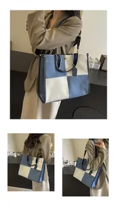 Detail of color-block canvas tote bag with blue denim patch and adjustable shoulder strap
