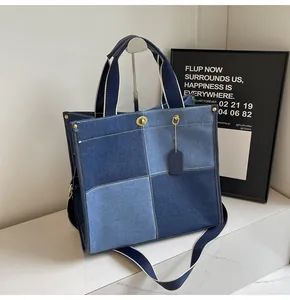 Detail of patchwork denim tote bag with metal turn-lock closure and adjustable strap