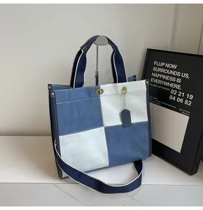 Detail view of the blue and beige checkered canvas tote bag with metal twist lock closure