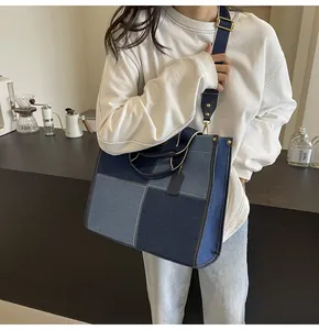 Detail view of denim patchwork tote bag with adjustable wide strap and metallic gold hardware