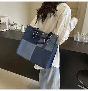 Detail of patchwork denim tote bag with metal twist lock and adjustable shoulder strap
