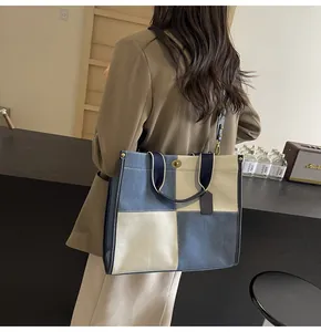 Detail of checkered denim tote bag with gold twist lock and adjustable shoulder strap