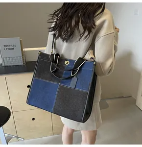 Detailed back view of a large navy and brown canvas tote bag featuring a gold twist lock