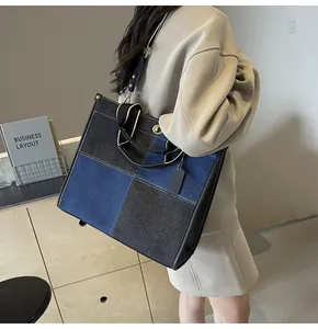 Detailed side view of a large patchwork tote bag featuring blue and grey denim panels
