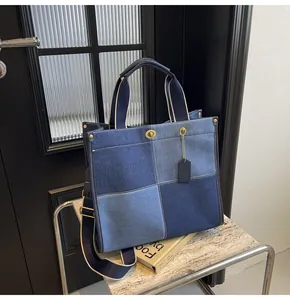 Detailed shot of denim patchwork tote bag with gold turnlock and adjustable strap