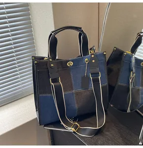 Detail of color-block canvas tote bag with metal turn-lock and adjustable wide strap