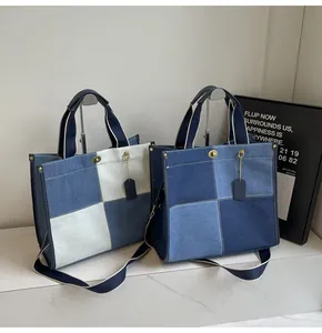 Detail of denim patchwork tote bags featuring gold hardware and hanging leather tags