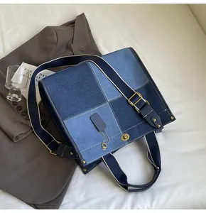 Detailed close-up of patchwork denim tote bag with metal lock on a stylish white bed setting