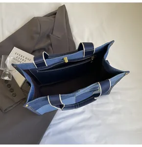 Detail view of the blue canvas tote bag interior with a secure gold zipper pocket
