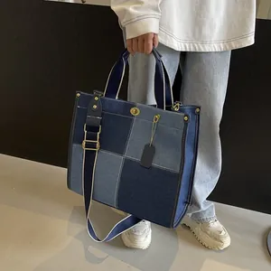 Large denim patchwork tote bag with gold hardware and adjustable wide shoulder strap