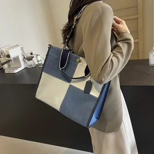 Chic blue and beige color-block tote bag with metal twist-lock and leather handles