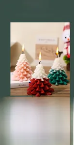 Detailed view of colorful Christmas tree scented candles on a cozy wooden holiday table