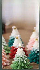 Macro detail of scented Christmas tree candles with golden bells on rustic wood surface