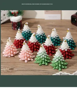 Detail of Christmas tree scented candles with two-tone design and small golden bells
