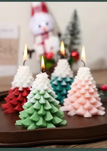 Macro detail of layered Christmas tree scented candles in four colors on a wooden tray
