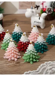 Close-up of Christmas tree shaped scented candles with festive bells on a cozy wooden desk