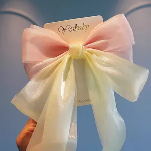 Detail of pink and yellow organza bow hair clip with shimmering pearlescent fabric