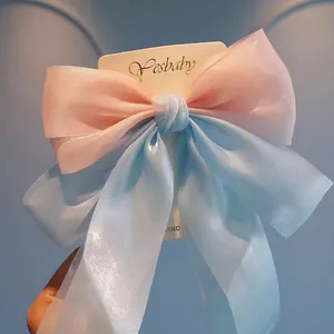 Detailed view of oversized iridescent mermaid bow hair clip with sheer organza fabric