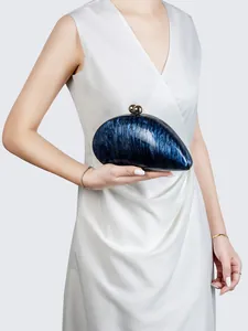 Detail of blue marble acrylic evening clutch bag with gold spherical double clasps