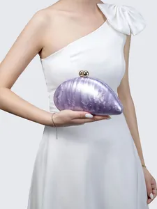 Detail of pearlescent marble acrylic evening clutch with gold ball clasp and chain