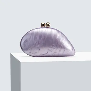 Close-up of purple marble acrylic evening bag with elegant golden clasp detail