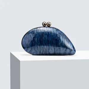 Close-up of blue marble acrylic clutch with elegant golden spherical double clasps