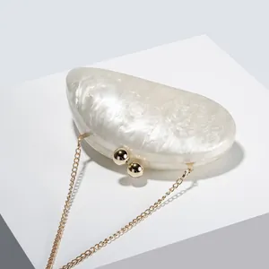 Detailed view of the marble texture acrylic half-moon clutch on a geometric stand