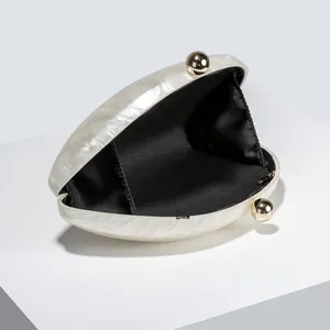 Detail of marble acrylic clutch with gold ball clasps and black fabric lining