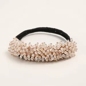 Elastic hair tie with white pearls and crystal beads on a clean beige background