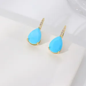Detailed close-up of water drop blue gemstone earrings with micro-pave gold setting