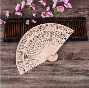 Detail view of intricate geometric hollow-carved patterns on an 8-inch wooden folding fan