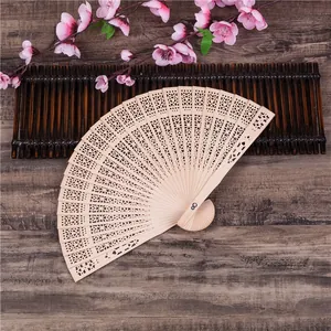 Chinese 8 inch hollow out wooden folding fan with intricate floral carvings on dark wood