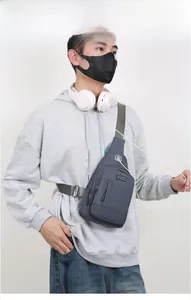 Detail of grey crossbody sling bag featuring a functional headphone port and durable fabric