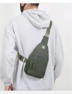 Detail view of army green nylon chest bag with adjustable strap and headphone jack on model