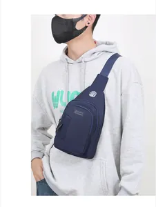 Detail of blue oxford fabric sling bag featuring a metal earphone port and front zipper pocket