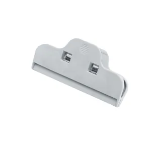 Detail of white plastic food sealer clip featuring internal dual metal spring mechanism