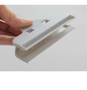 Detail showing the large gray food sealing clip with wide opening and strong grip mechanism