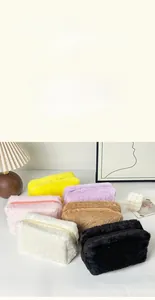Detail of plush cosmetic bags in multiple colors featuring soft texture and zipper closure