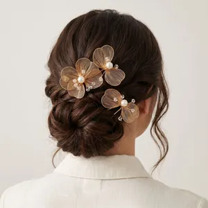 Detailed close-up of golden handmade wire-woven flower hairpins with pearls and crystals