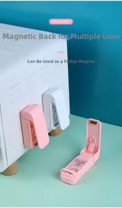 Mini-Heißsiegelgerät in Rosa und Weiß mit Magnetrückseite an einer Ofenoberfläche