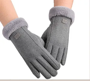 Detailed close-up of gray thermal gloves with plush faux fur cuffs and fashion labels
