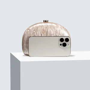 Detail of marble acrylic clutch bag showing internal capacity compared to a smartphone