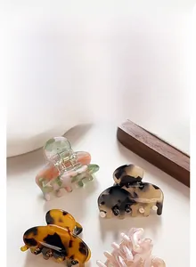 Detailed view of four different patterned resin hair clips with strong metal springs