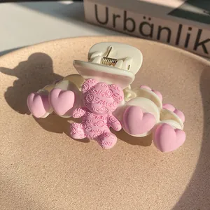 Detail of a large shark clip with pink 3D bears and hearts on a creamy matte finish