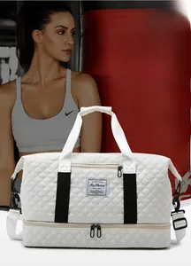 Detail of white quilted gym bag featuring independent bottom shoe compartment and handles