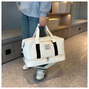 Macro detail of white quilted travel bag with bottom compartment and adjustable strap