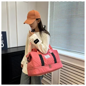 Quilted pink travel bag with separate shoe compartment shown on model for fitness or travel