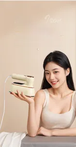 Close-up of portable steam iron with large metal plate and woman holding the device