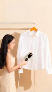 Detail of portable handheld steamer with LED display ironing a white shirt